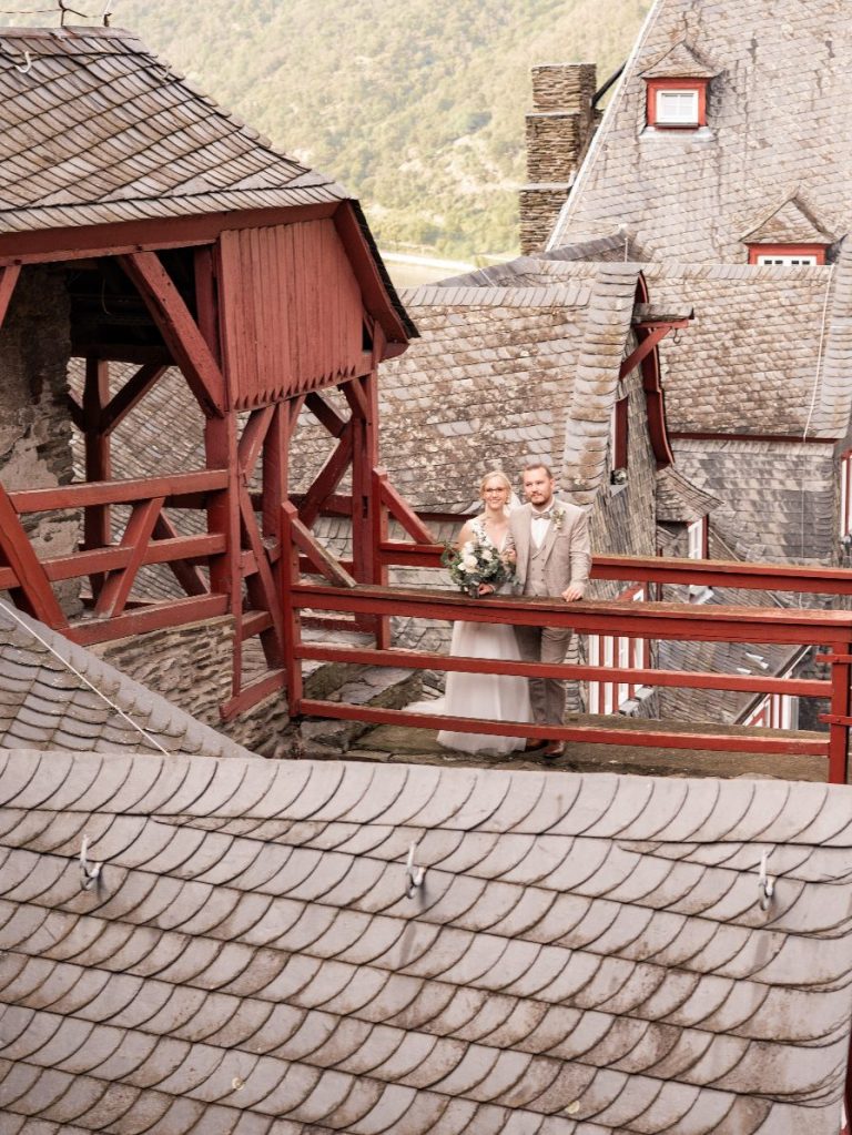 Hoch über den Dächern der Burg steht das frisch verheiratete Paar